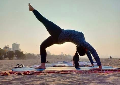 person practicing yoga on the beach 